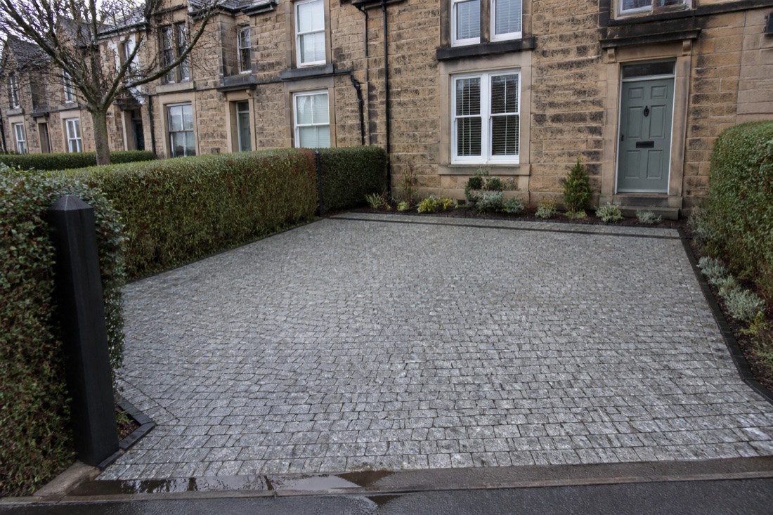 Front garden converted to permeable granite sett parking with a clipped hedge